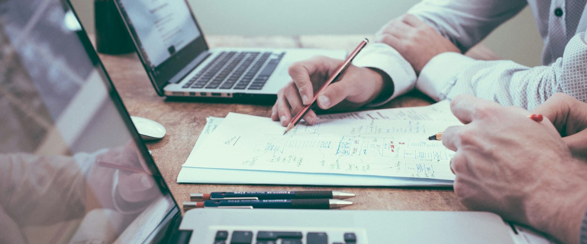 Analysts reviewing figures on laptops and paper